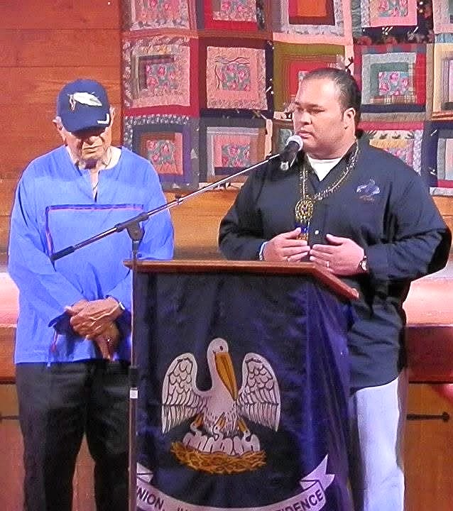 Speaking at a podium beneath the Louisiana colors